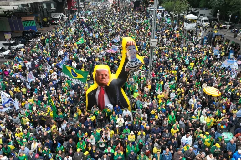 Supporters of opposition presidential candidate Flavio Bolsonaro march with an effigy of U.S. President Donald Trump holding a doll depicting Brazilian President Luiz Inacio Lula da Silva as a prisoner, during an Independence Day event in Sao Paulo, Brazil, Monday, Sept. 7, 2026, the month before the general election. (AP Photo/Andre Penner)